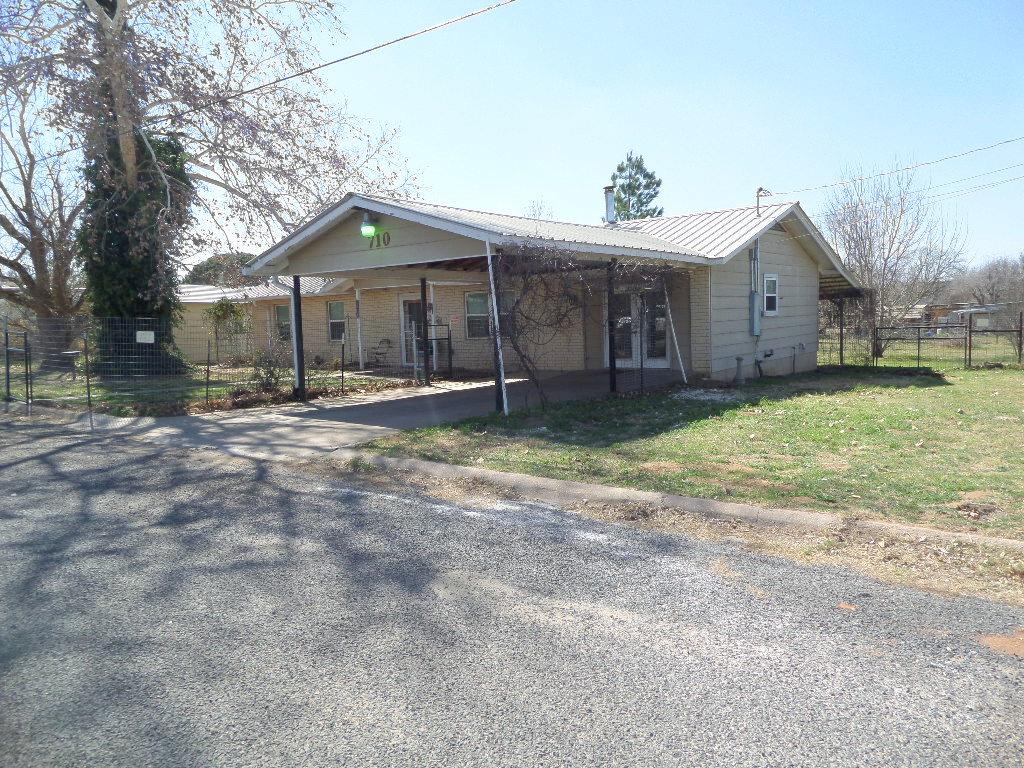 a wooden house with a yard and large tree