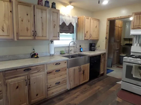 a kitchen with stainless steel appliances granite countertop a sink a stove a refrigerator and cabinets