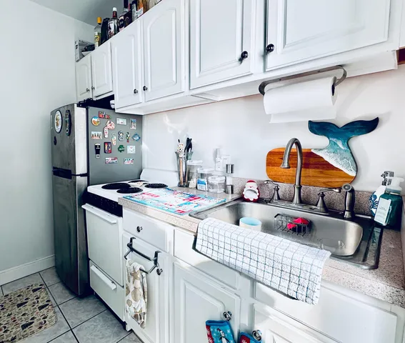 a kitchen with stainless steel appliances granite countertop a sink stove and white cabinets