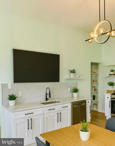 a kitchen with stainless steel appliances granite countertop a sink and a white cabinets