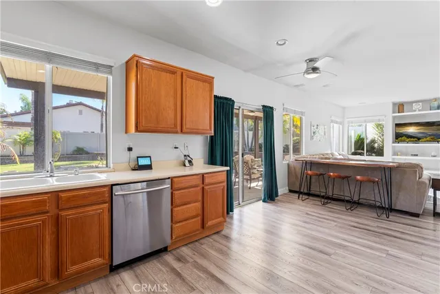 a kitchen with stainless steel appliances a sink cabinets and wooden floor