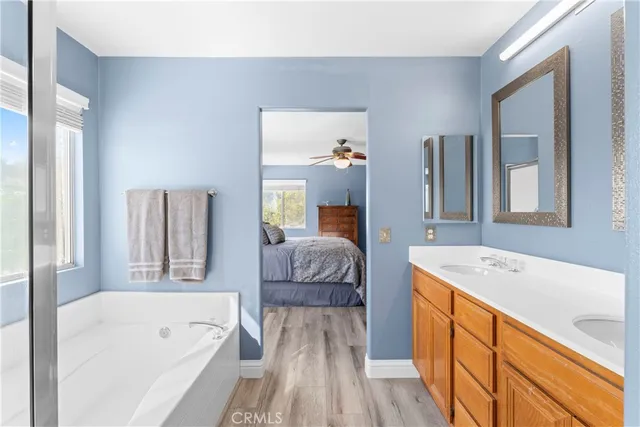 a spacious bathroom with a granite countertop tub sink and mirror