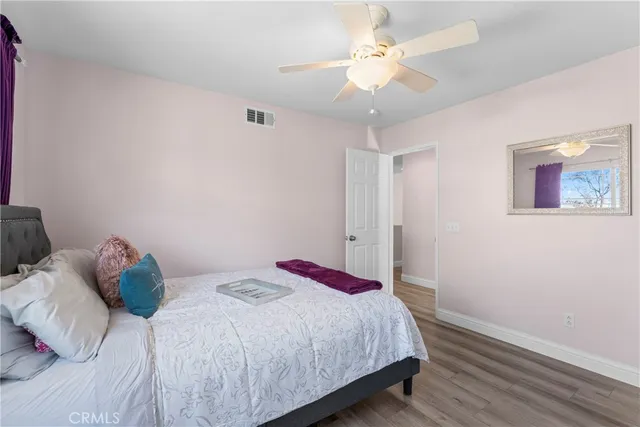a bedroom with a bed and a ceiling fan