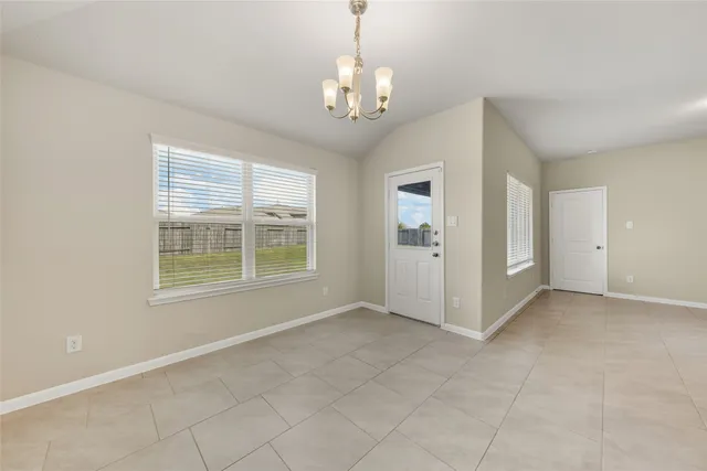 an empty room with chandelier and windows