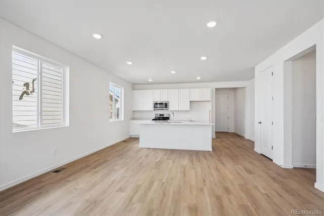 a large kitchen with kitchen island white cabinets and wooden floor
