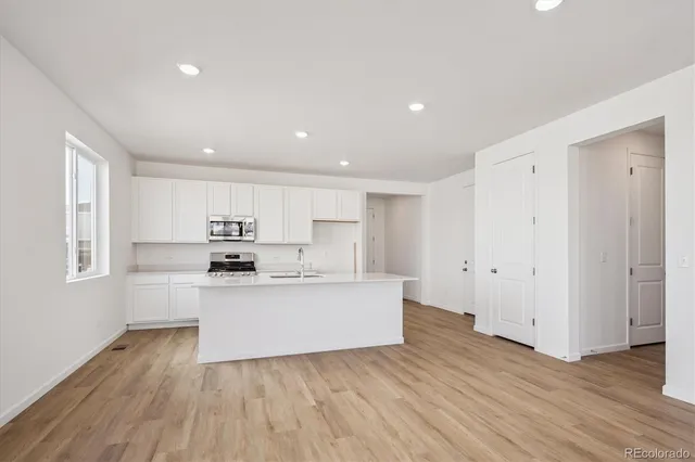 a view of kitchen with wooden floor and electronic appliances