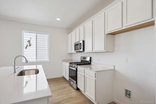 a kitchen with stainless steel appliances granite countertop a sink stove and cabinets