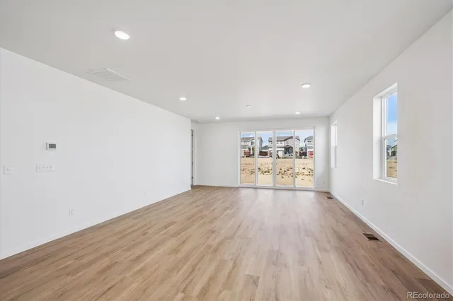 a view of a room with wooden floor and window