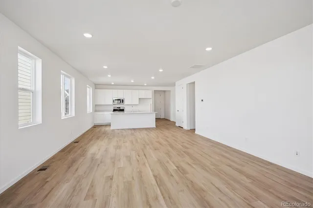 a view of a kitchen with wooden floor and windows