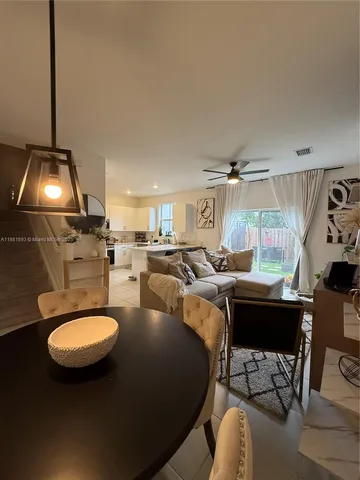 a living room with furniture a chandelier and a rug
