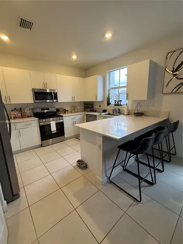 a kitchen with a sink a stove and chairs