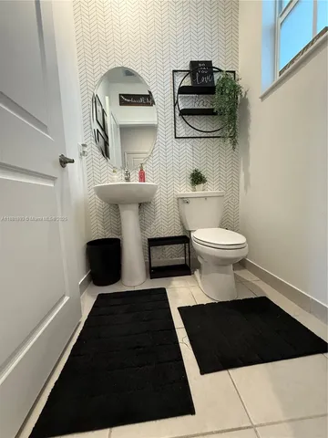 a bathroom with a toilet a sink and a mirror
