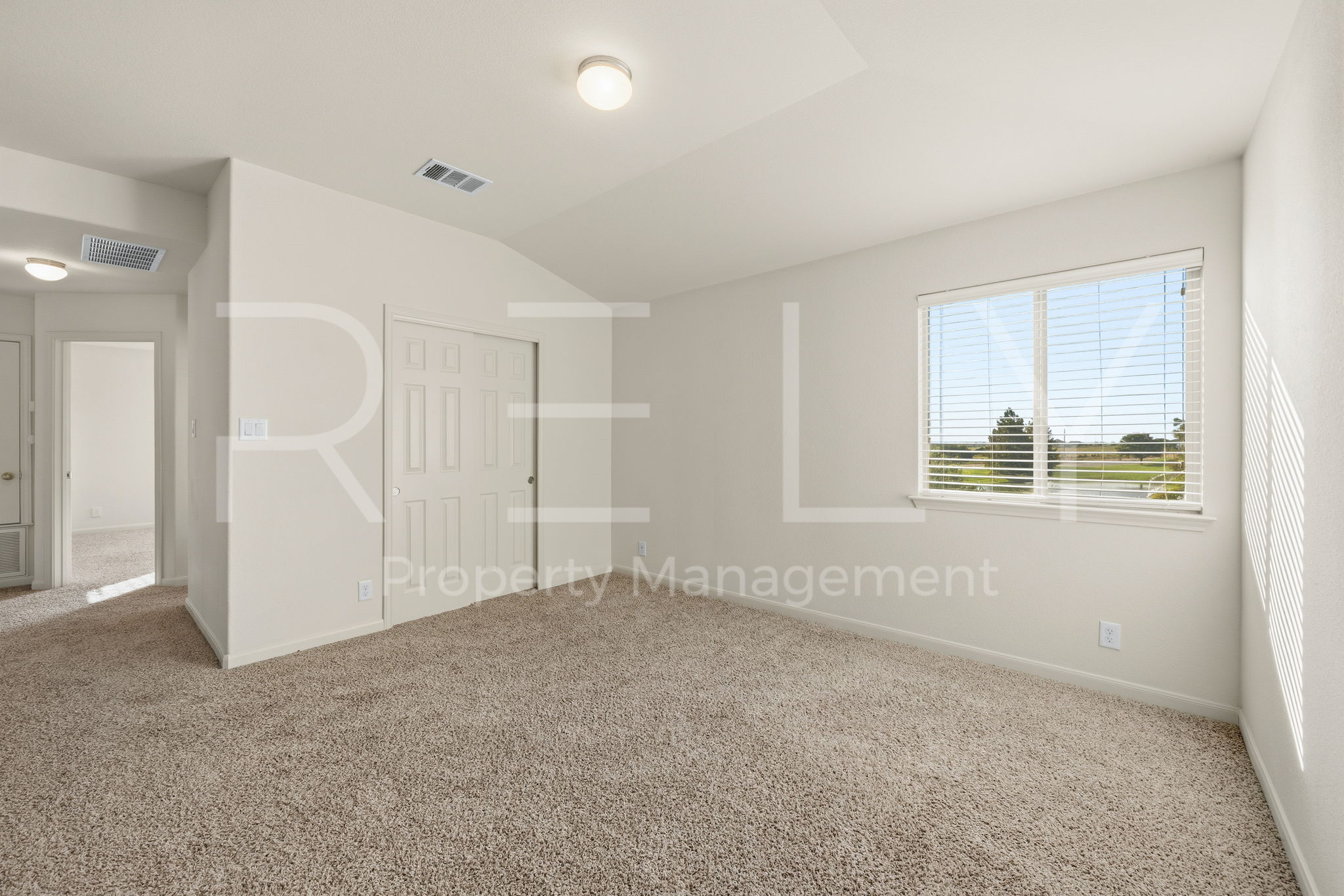 1405 Sunny Meadows Loop Georgetown, TX 78626 - Photo 25 of 40 A well-lit bedroom features plush carpeting and a large window overlooking natural scenery.