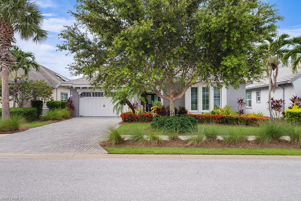 5154 Andros Drive Naples, FL 34113 - Photo 2 of 46 a front view of a house with a yard and shrubs