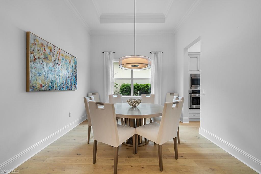5154 Andros Drive Naples, FL 34113 - Photo 22 of 46 a dining room with furniture a rug and wooden floor