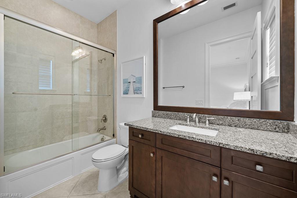 5154 Andros Drive Naples, FL 34113 - Photo 28 of 46 a bathroom with a granite countertop sink toilet mirror and shower