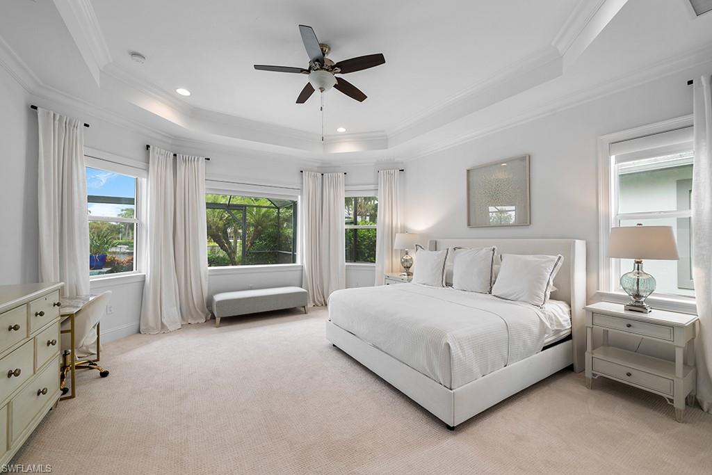 5154 Andros Drive Naples, FL 34113 - Photo 29 of 46 a spacious bedroom with a bed a couch and large window