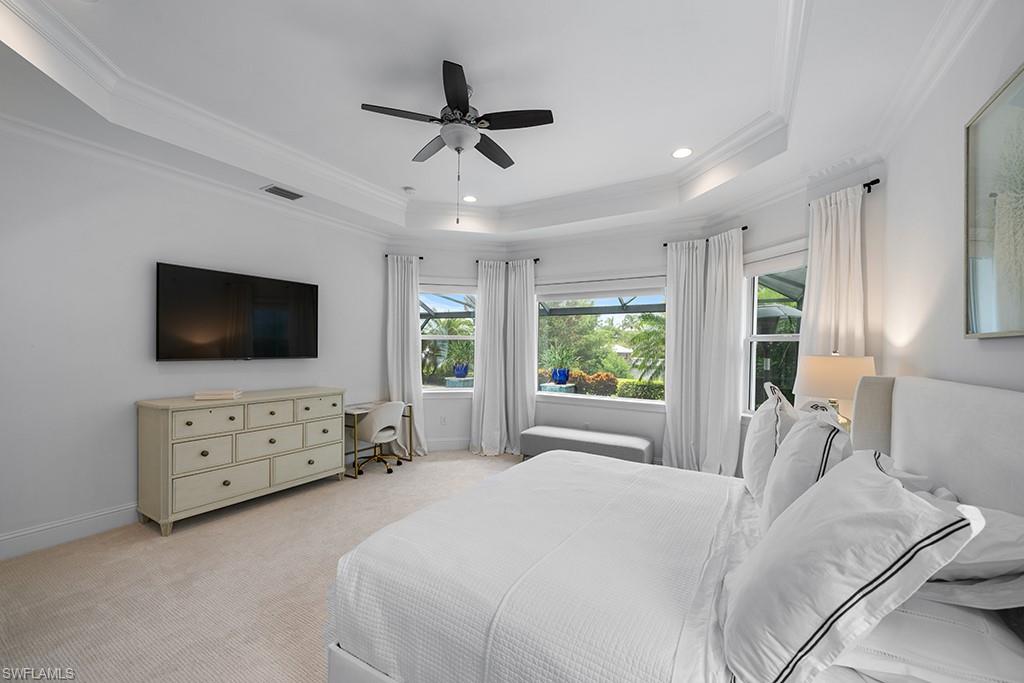5154 Andros Drive Naples, FL 34113 - Photo 30 of 46 a spacious bedroom with a bed and a flat screen tv