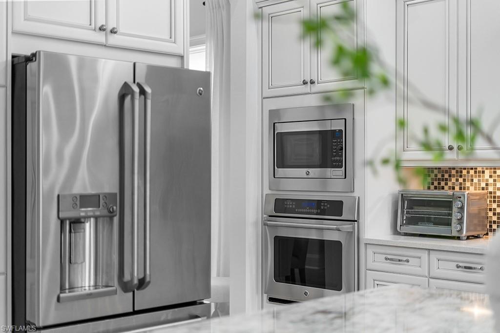5154 Andros Drive Naples, FL 34113 - Photo 38 of 46 a kitchen with windows and fireplace