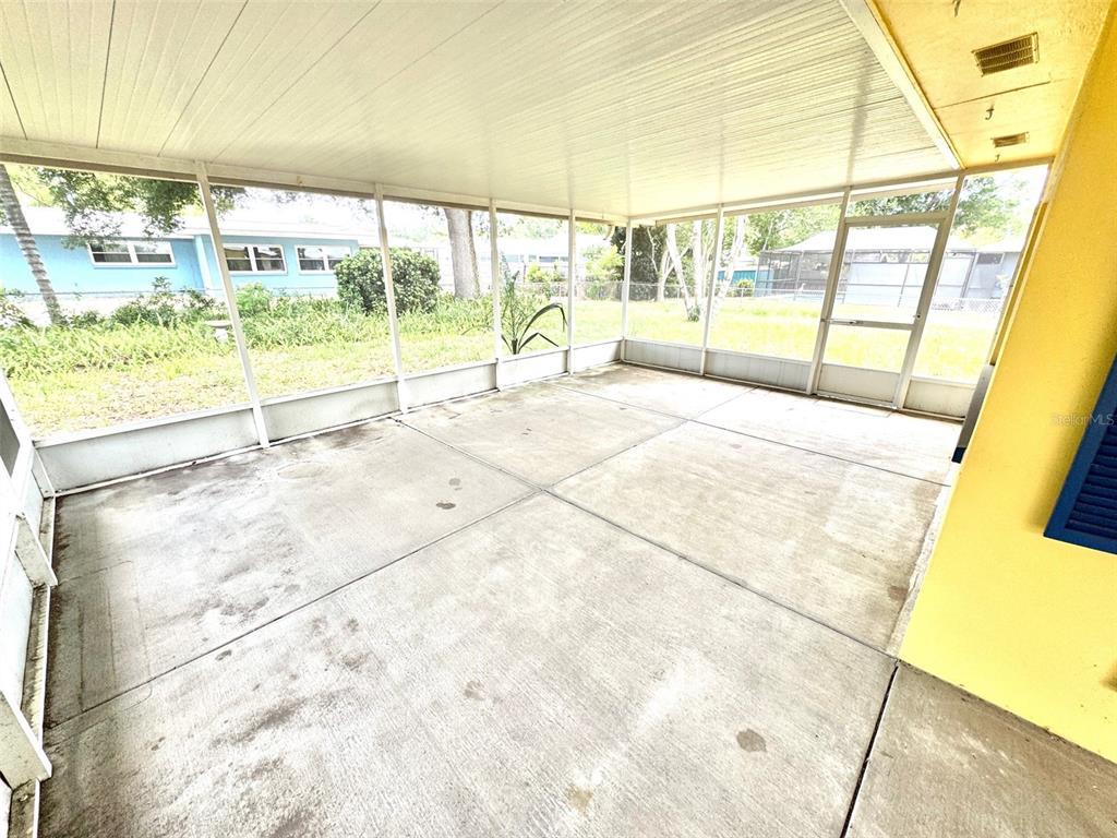 1035 Robmar Road Dunedin, FL 34698 - Photo 27 of 40 a view of an empty room with wooden floor and a floor to ceiling window