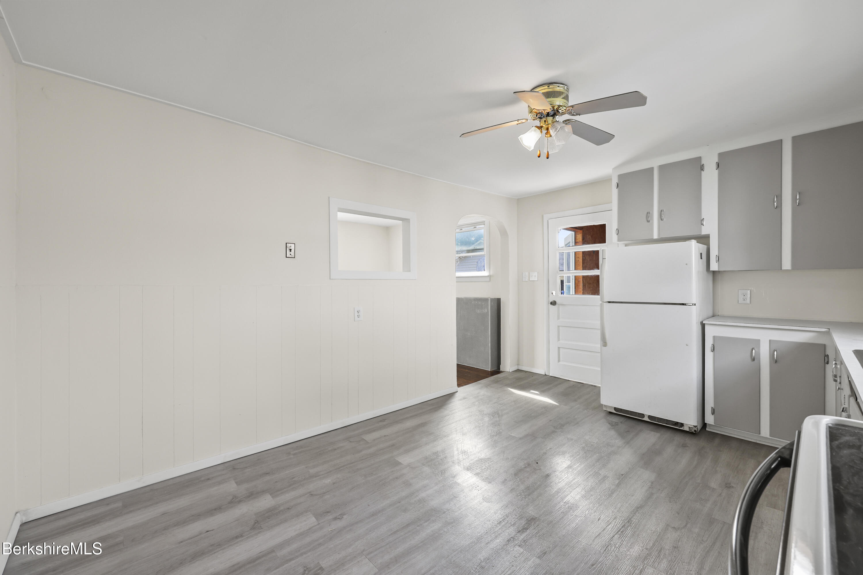 49 McArthur Street Pittsfield, MA 01201 - Photo 15 of 33 a view of a kitchen with a refrigerator a ceiling fan and wooden floor