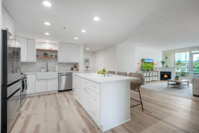 a large white kitchen with lots of counter space a sink appliances and cabinets