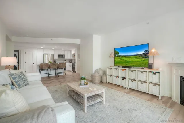 a living room with furniture a flat screen tv and floor to ceiling window