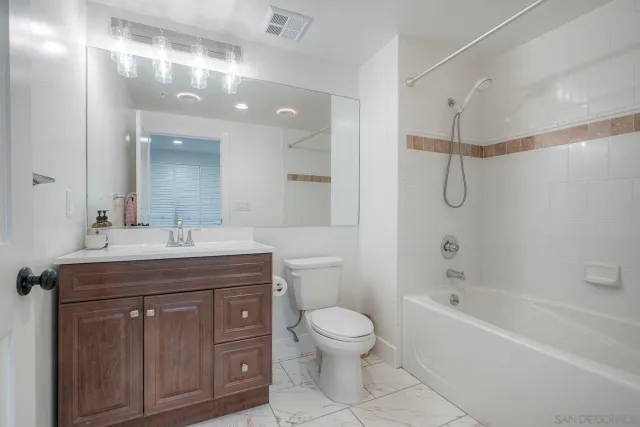 a spacious bathroom with a granite countertop sink a toilet and shower