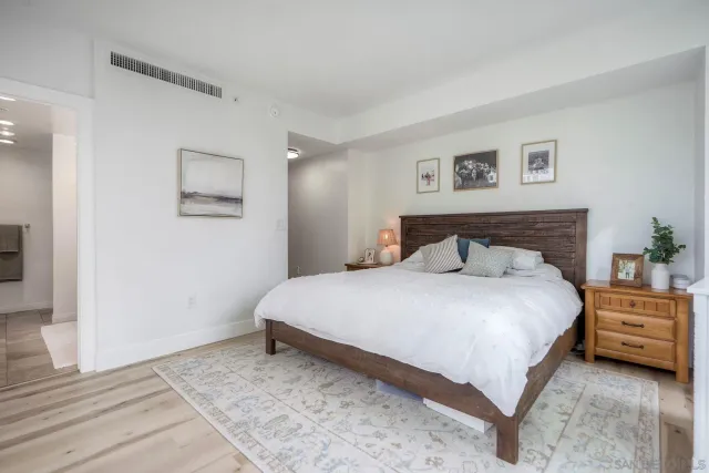 a bedroom with a bed and a painting on the wall