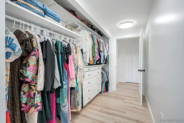 a view of walk in closet with clothes