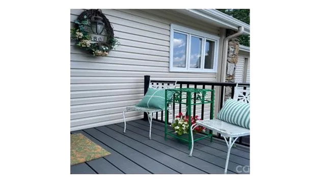 a balcony with wooden floor and outdoor seating