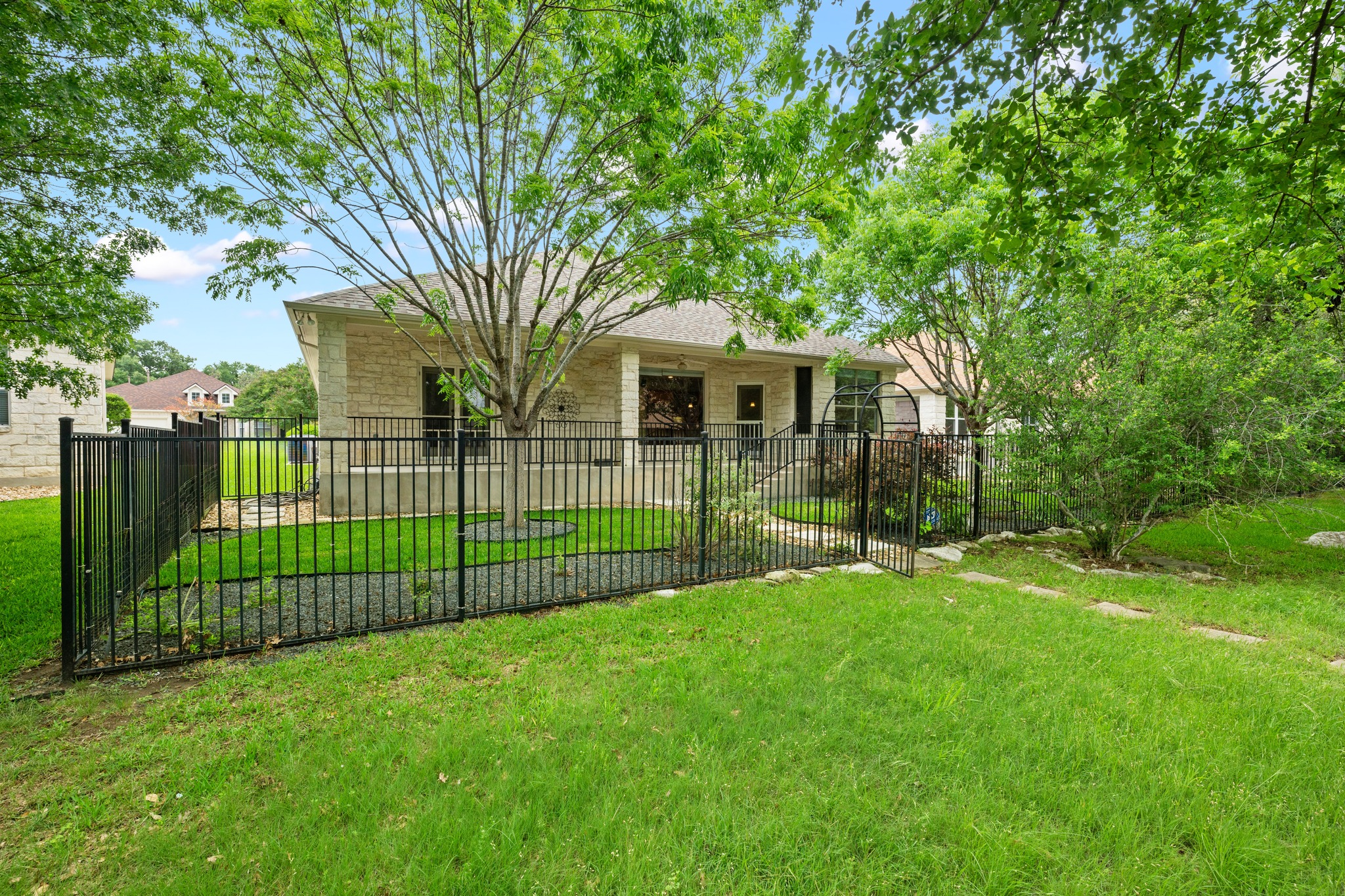 815 River Walk Trail Georgetown, TX 78633 - Photo 31 of 36 A wrought iron fence keeps the view open to the greenery while providing a secure perimeter for a pet