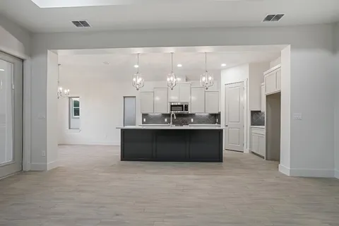 a living room with stainless steel appliances kitchen island granite countertop furniture and a large window