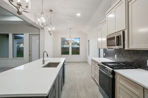 a kitchen with a sink stove and microwave