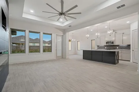 a view of kitchen with kitchen island stainless steel appliances wooden floor and window