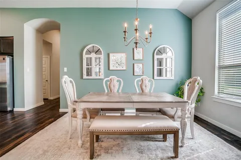 a view of a dining room with furniture and chandelier