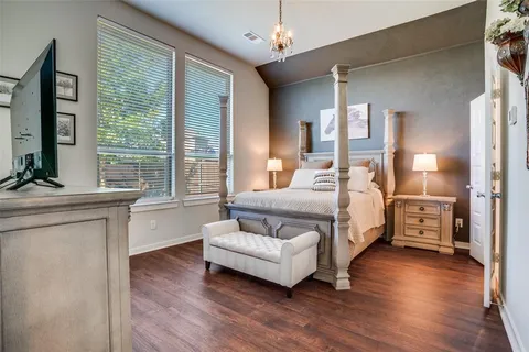 a spacious bedroom with a bed and wooden floor