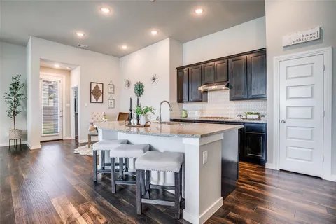 a kitchen with stainless steel appliances kitchen island granite countertop a stove refrigerator and cabinets
