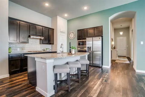 a kitchen with stainless steel appliances a refrigerator stove microwave and cabinets