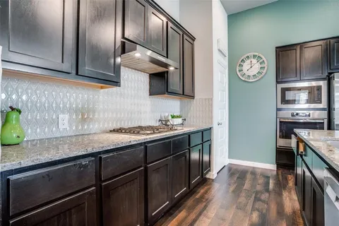 a kitchen with granite countertop stainless steel appliances and wooden cabinets