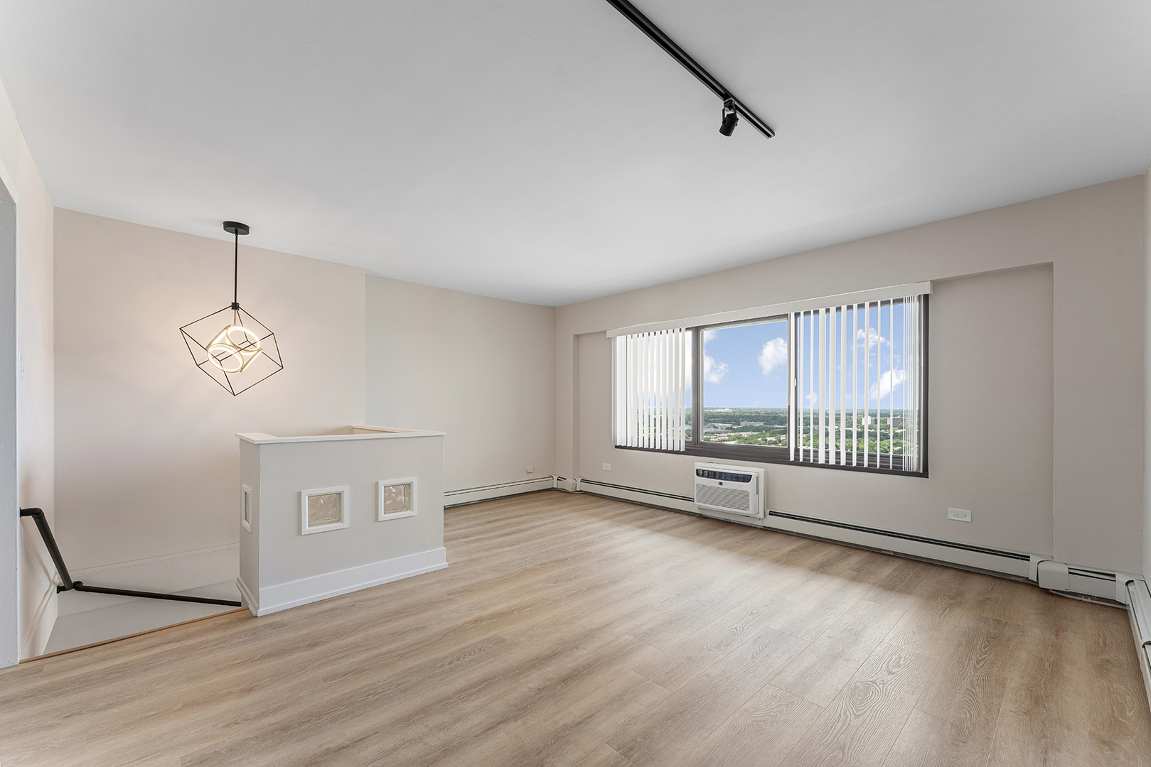 6166 North Sheridan Road, Unit 16A Chicago, IL 60660 - Photo 6 of 17 a view of an empty room with a window and wooden floor
