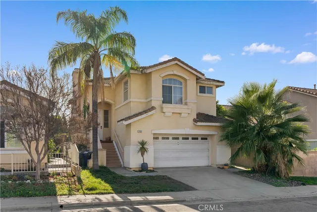 a front view of a house with a yard and palm trees