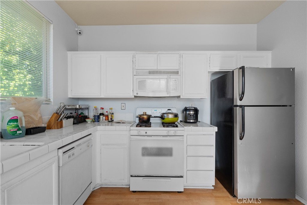 11159 St Tropez Drive Rancho Cucamonga, CA 91730 - Photo 22 of 40 a kitchen with stainless steel appliances white cabinets and a refrigerator