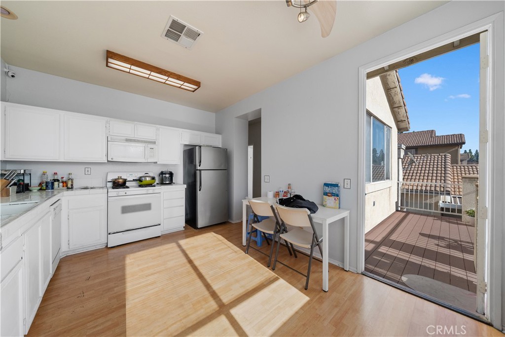 11159 St Tropez Drive Rancho Cucamonga, CA 91730 - Photo 23 of 40 a kitchen with a refrigerator and white cabinets