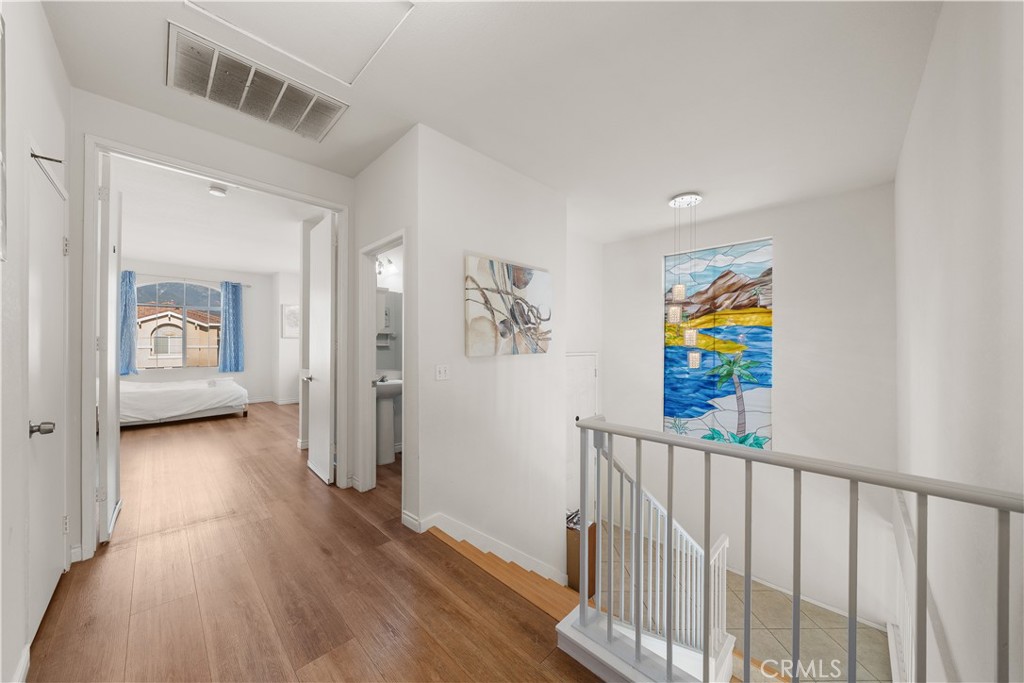11159 St Tropez Drive Rancho Cucamonga, CA 91730 - Photo 27 of 40 a view of a hallway to a livingroom with wooden floor and furniture