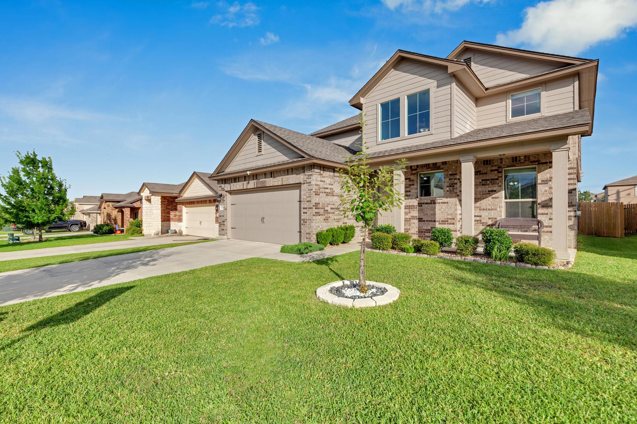 104 Uncle Billy Way Jarrell, TX 76537 - Photo 3 of 38 A welcoming front exterior showcasing a blend of brick and siding, with a well-maintained lawn.