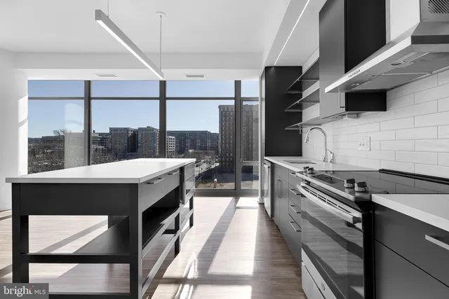a kitchen with a refrigerator a sink and wooden floor