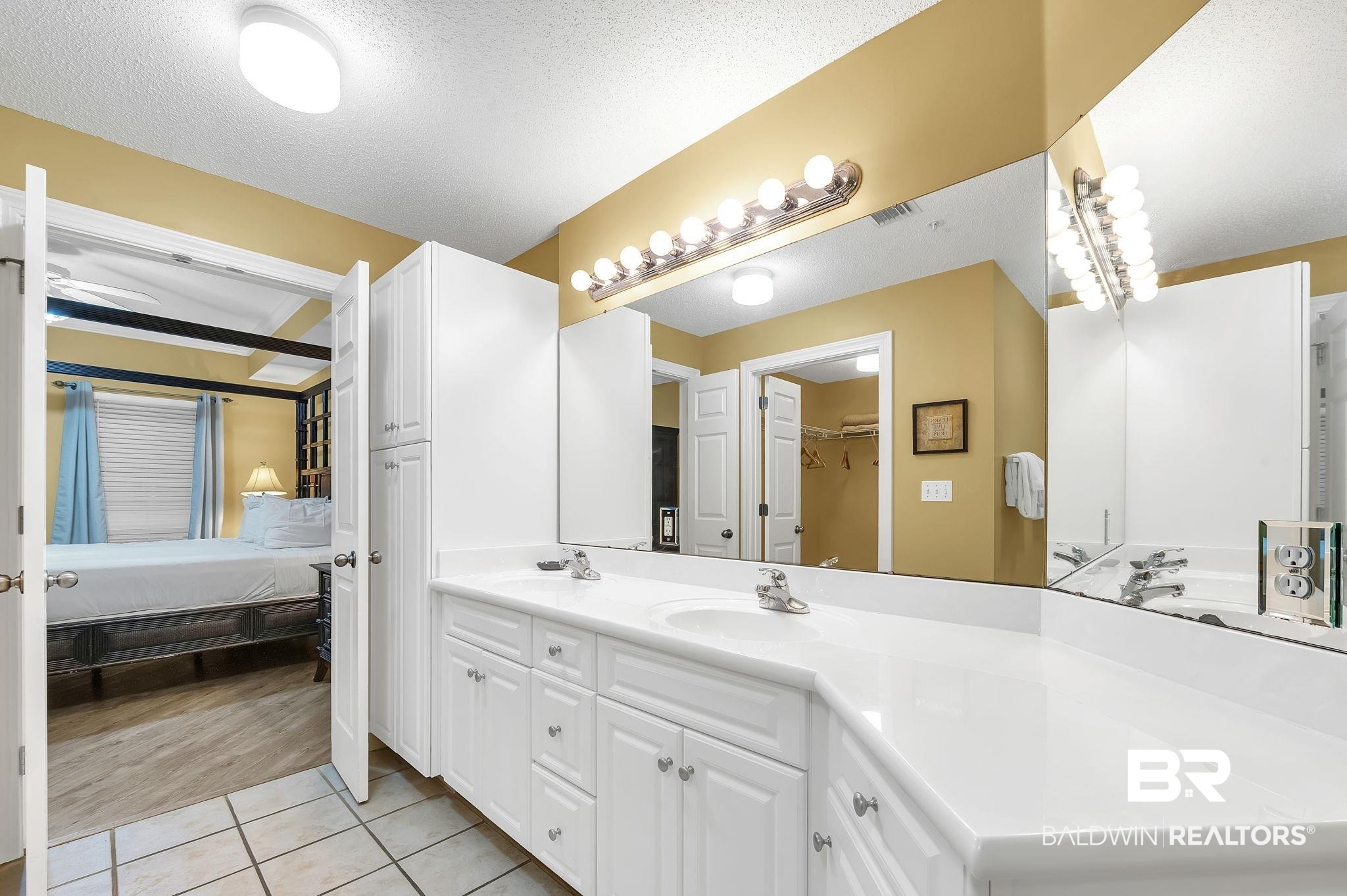 27580 Canal Road, Unit 1214 AND BOAT SLIP #62 Orange Beach, AL 36561 - Photo 31 of 67 Ensuite bathroom featuring ensuite bathroom, a textured ceiling, vanity, a spacious closet, and tile patterned flooring
