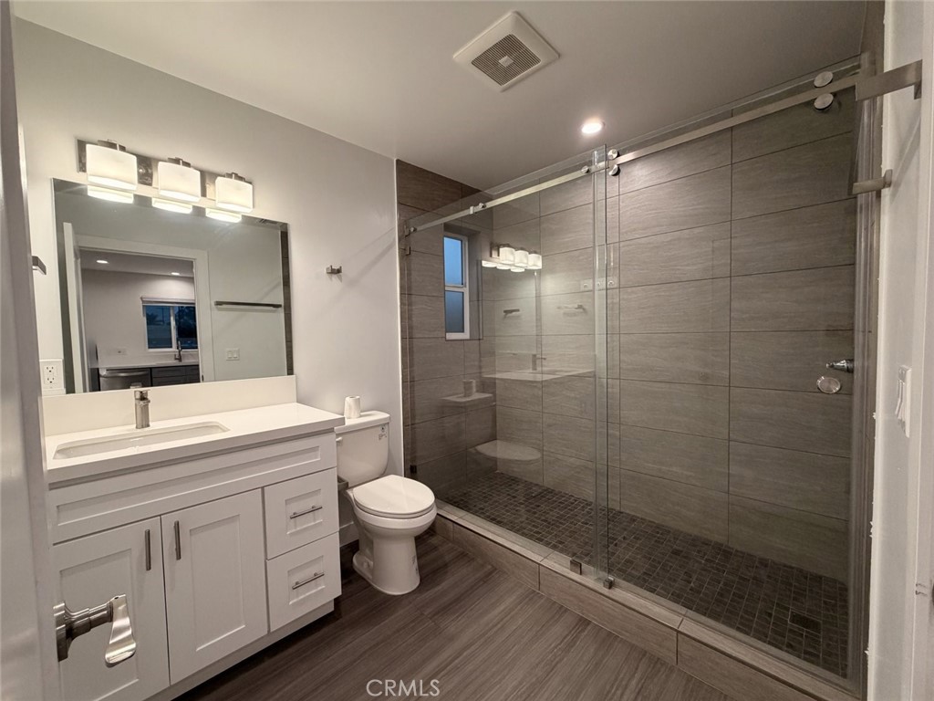 511 North Azusa Avenue, Unit 203 Azusa, CA 91702 - Photo 6 of 16 a bathroom with a double vanity sink toilet a mirror and shower
