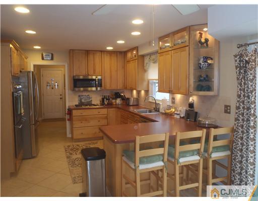 27 Cartwright Drive West Windsor, NJ 08550 - Photo 3 of 14 a kitchen with a dining table chairs sink and refrigerator